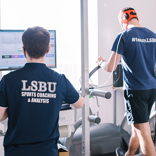 A participant on a treadmill hooked up to a monitor by electrodes
